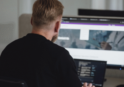 Vīrietis pie datora ar glikozes mērītājs